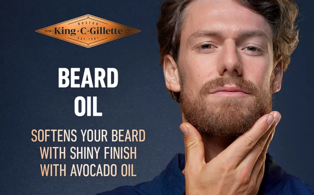 A man applying King C. Gillette Beard Oil with a shiny finish to his beard.
