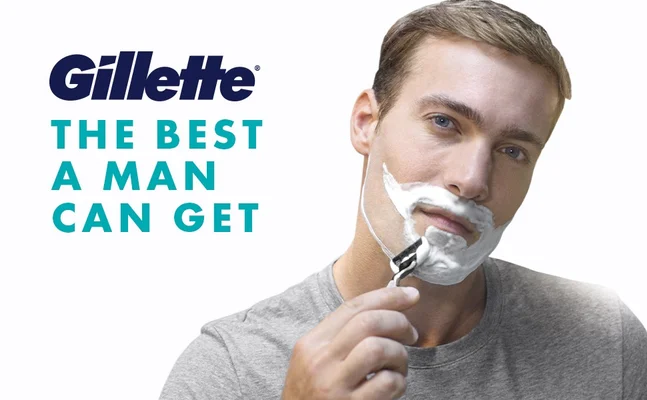 Person shaving with a Gillette razor and shaving foam, featuring Gillette slogan.