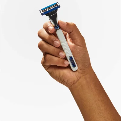 Gillette Mach3 Turbo razor held in hand, showcasing its three blades and ergonomic white handle.