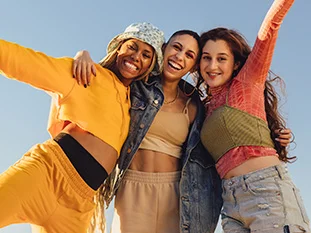 Three women smiling and hugging each other
